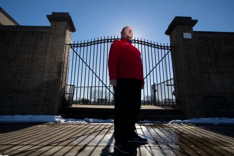 Frankford High School football coach Bill Sytsma, standing in front of the gates to the school's football stadium, has lost four players in recent years to gun violence.