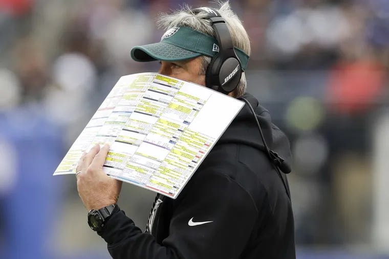 Eagles Head Coach Doug Pederson uses his play chart to cover his mouth against the New York Giants on Sunday, December 17, 2017. YONG KIM / Staff Photographer