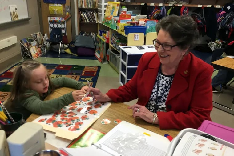 Senior volunteer Lorraine Ferraro helps Laina De Carlo identify letters at Pottstown's Lincoln Elementary School.