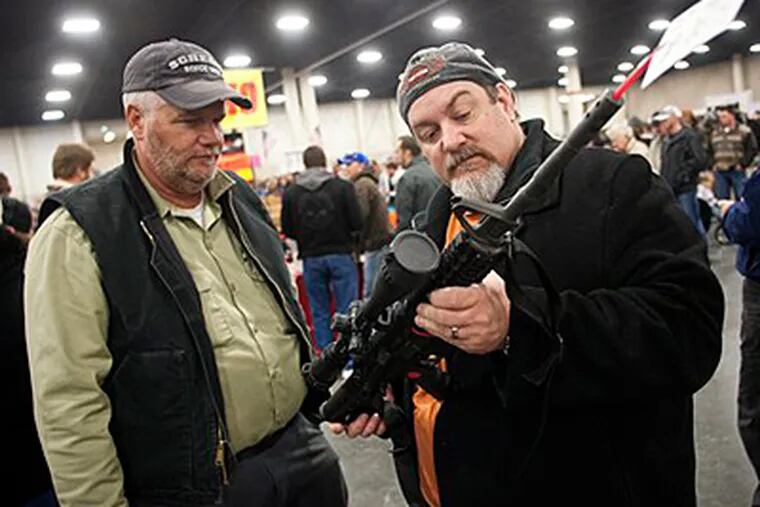 FILE - In a Saturday, Jan. 5, 2013 file photo, gun owners discuss an AR-15, during the 2013 Rocky Mountain Gun Show at the South Towne Expo Center in Sandy, Utah. (AP Photo/The Deseret News, Ben Brewer, File)