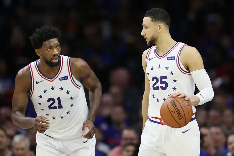 The Sixers' Joel Embiid (21) talking with teammate Ben Simmons (25) during a game.
