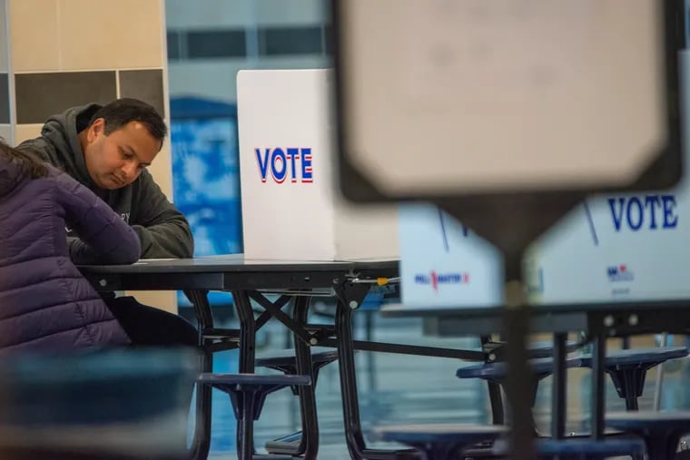 A voter casts his ballot in November 2022 at Bensalem High School.