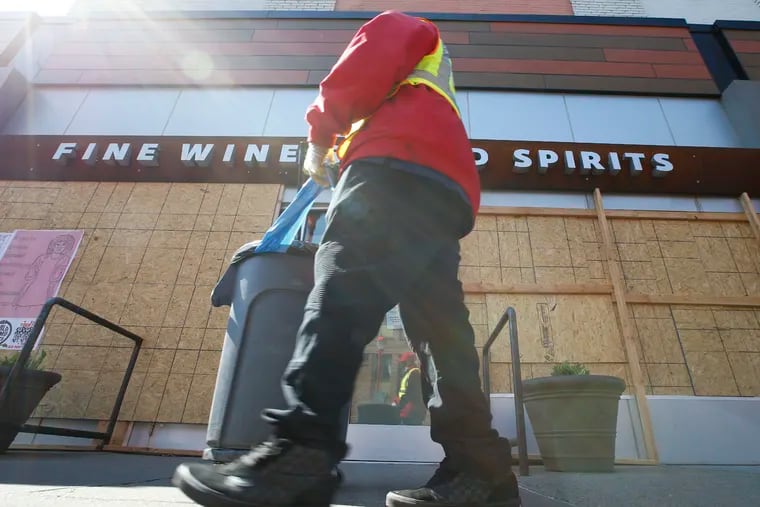 A South Street Headhouse District sidewalk and street cleaner moves past a Fine Wine & Good Spirits Premium Collection store on the 700 block of South Street on Sunday, April 19, 2020.  Some of Pennsylvania’s state-run liquor stores will be offering curbside pickups on a limited basis, starting Monday.