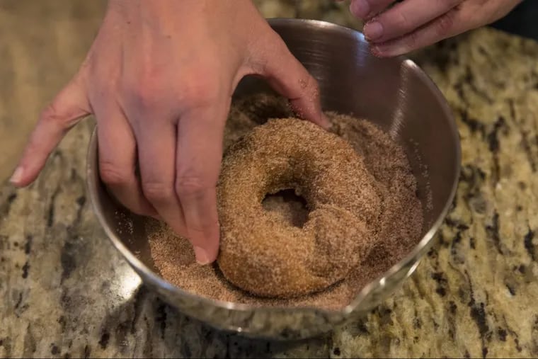 After the doughnut is fried it is coated with various sugar and spices.