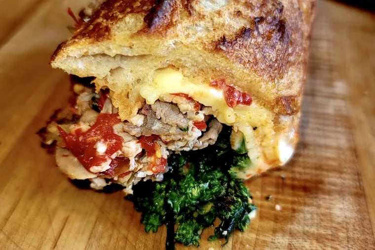 The pork hoagie from the Cip's House of Hoagies pop-up, served warm, has confit pork shoulder, broccoli rabe, Calabrian chili mayo, and St. Malachi cheese.