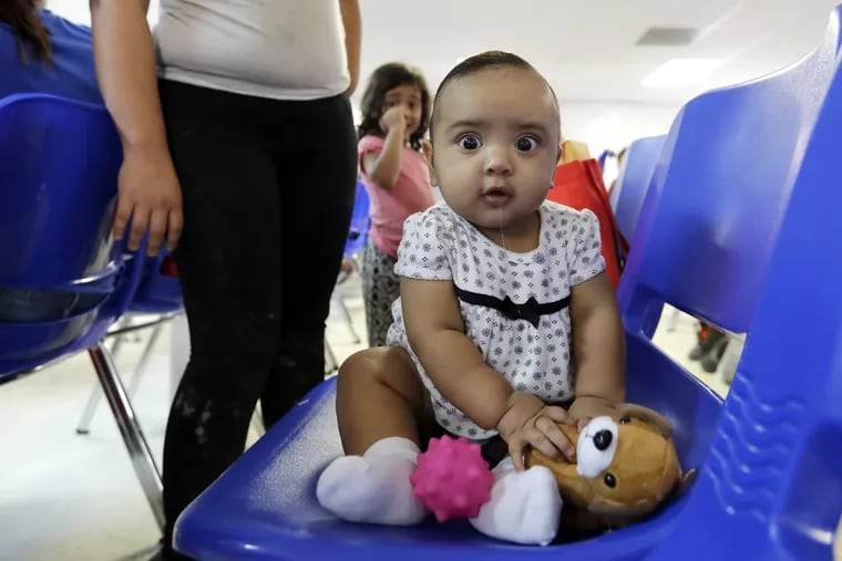 An immigrant infant plays with a stuffed animal inside the Catholic Charities of the Rio Grande Valley on Saturday, June 23, 2018, in McAllen, Texas.