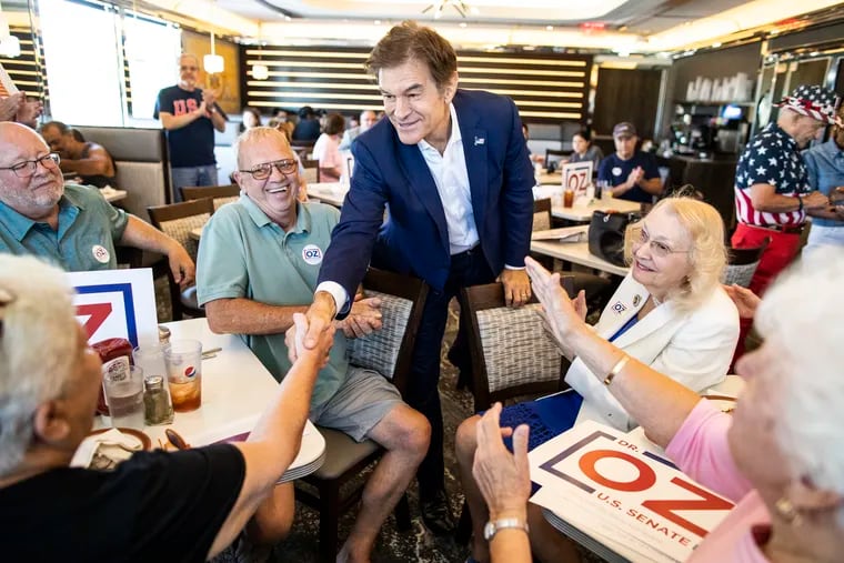 Republican nominee for U.S. Senate, Mehmet Oz, center, shakes hands with supporters in Swatara Township on Friday.