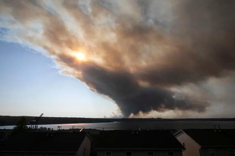Thick plumes of heavy smoke fill the Halifax sky as an out-of-control fire in a suburban community quickly spread, engulfing multiple homes and forcing the evacuation of local residents, in Halifax, Nova Scotia, on Sunday.