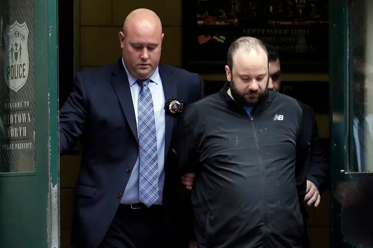 Marc Lamparello, 37, is escorted out of a police precinct in New York, Thursday, April 18, 2019. Police say Lamparello was arrested after entering St. Patrick's Cathedral Wednesday night in New York with two cans of gasoline, lighter fluid and butane lighters. Lamparello is facing charges including attempted arson and reckless endangerment.