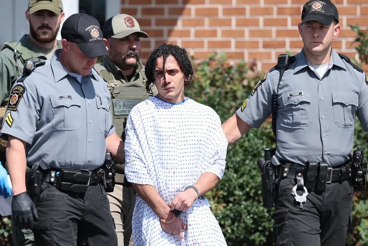 Danilo Cavalcante is escorted from the Pennsylvania State Police barracks in Avondale on Sept. 13.