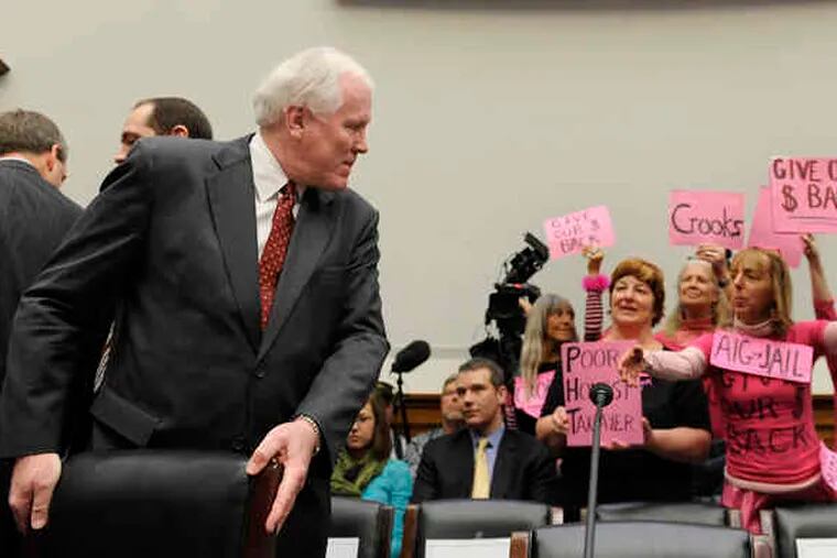 AIG CEO Edward M. Liddy noticing protesters as he prepares to testify before Congress.