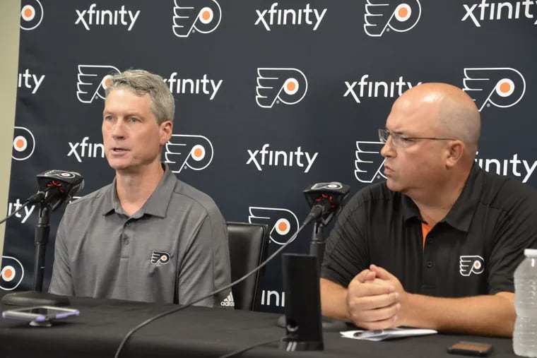 Flyers general manager Chuck Fletcher (left) and assistant GM Brent Flahr discuss the team's draft possibilities on Tuesday.
