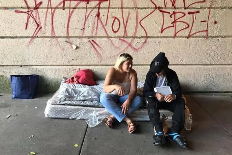 Jessie Alejandro-Cruz sit and talks with one of the homeless drug users at Emerald Street.