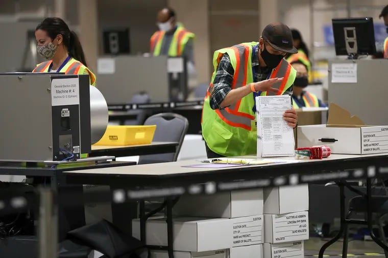 Workers count Philadelphia mail ballots inside the Pennsylvania Convention Center last November.