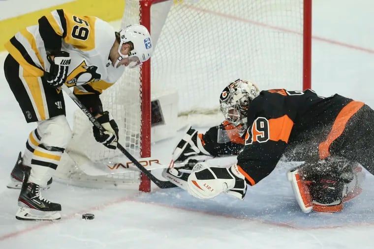 Goalie Carter Hart makes a diving save against the Penguins' Jake Guentzel during the Flyers' 5-2 win on Jan. 15. The teams will meet three times this week in Pittsburgh.