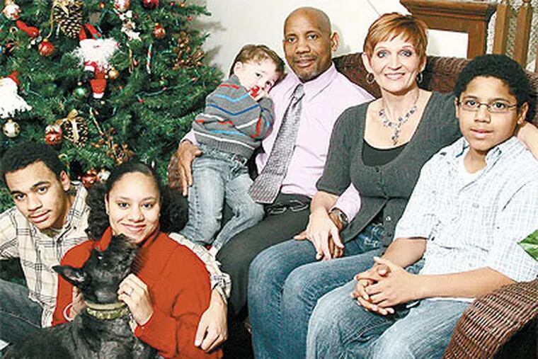 The Thomas family of Chester: (fromright of tree) Jordan, 3 (in dad's arms), John and Jane Thomas, Jonathan, 12, Isaiah, 16, and Alaina, 15 (bottom right). Ooops, almost forgot Murphy, the family pet. (Stephen M. Falk / Staff Photographer)