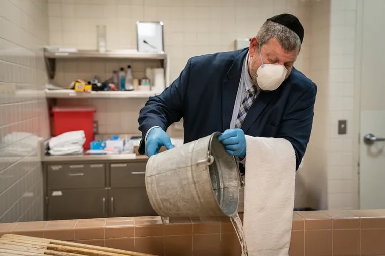 David Kushner demonstrates how he would wash the deceased if he were performing a tahara at a mikveh at the Levine Funeral Home in Trevose.