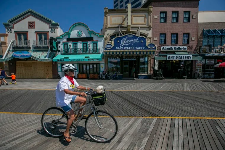 A bicyclist with their dog in a basket enjoys the Boardwalk in Atlantic City on Tuesday. Outdoor amusement and water parks in New Jersey can reopen July 2, including rides on boardwalks.