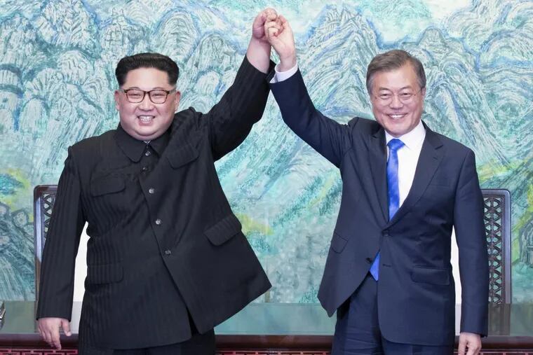 North Korean leader Kim Jong Un, left, and South Korean President Moon Jae-in raise their hands after signing on a joint statement at the border village of Panmunjom in the Demilitarized Zone, South Korea, Friday, April 27, 2018.