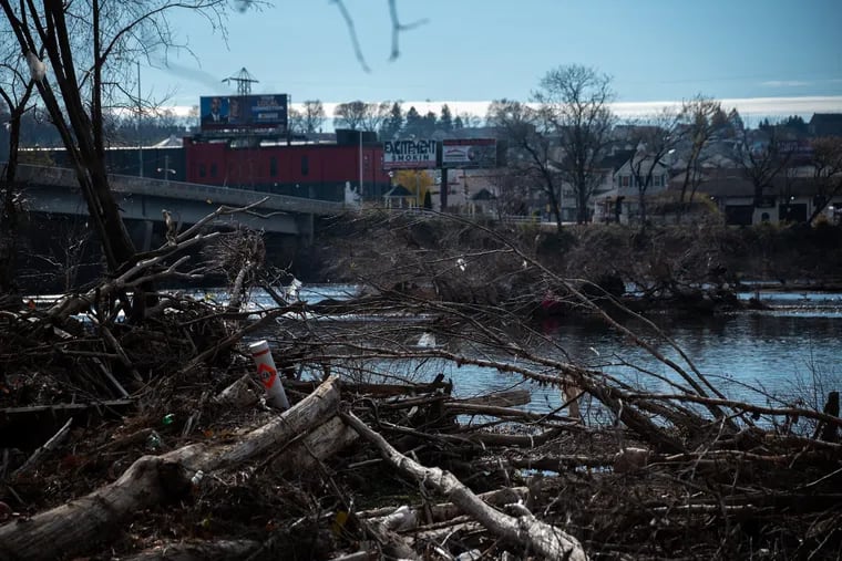 The Schuykill River flows by the river banks of the Riverside Apartments in Norristown, PA on the morning of Sunday, Dec. 5, 2021. The banks were covered in fallen trees and debris following 27 feet of flooding caused by Hurricane Ida in early September 2021.
