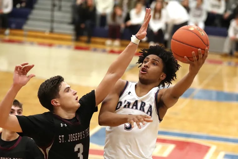 Tre Dinkins of Cardinal O’Hara shoots over Chris Arizin of St. Joseph’s Prep during Friday night' Catholic League game. Dinkins scored 24 to lead the Lions to a 63-50 victory.
