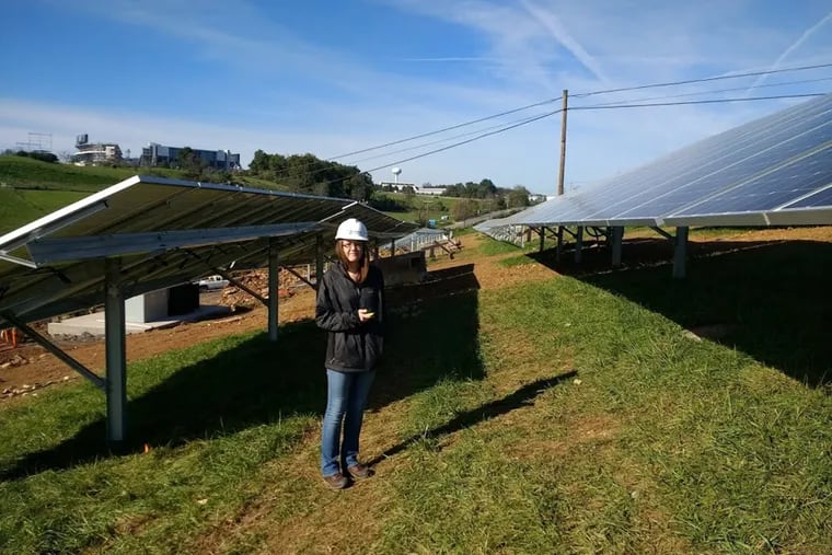 A Penn State student working among the 10 acres of solar panels at the university's main campus.
