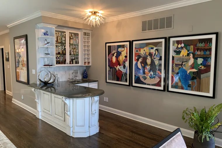 The Kanevskys remodeled a formal living into a more comfortable space including a bar. They found a large, colorful painting by Itzchak Tarkay that they broke down the triptych to showcase it in three individual black lacquer frames.