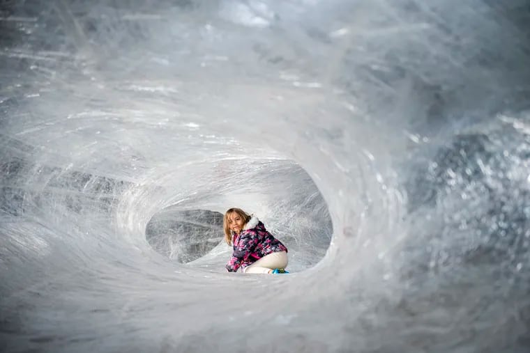 Basma Akabouche, 7, sits inside the tape cocoon, the Navy Yard's funky art installation.
