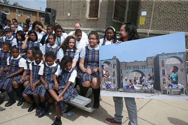 Artist Ceasar Viveros, right, shows off the mural planned for the future home of Saint Malachy school during the Thursday announcement of a new mural to commemorate the visit by Pope Francis to Philadelphia. DAVID MAIALETTI / Staff Photographer