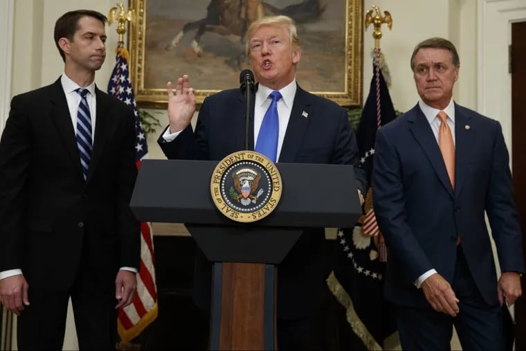 Sen. Tom Cotton, R- Ark., left, and Sen. David Perdue, R-Ga., right, look on as President Donald Trump speaks during the unveiling of legislation that would place new limits on legal immigration, in the Roosevelt Room of the White House, Wednesday, Aug. 2, 2017, in Washington. (AP Photo/Evan Vucci) .
