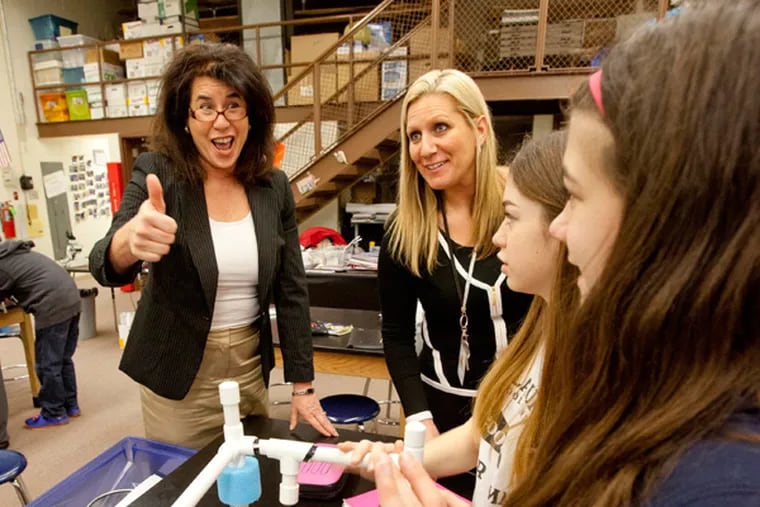 Antoinette Rath, left, Mount Laurel schools superintendent, gives a thumbs up to students (second from right) Madeleine Berks and (right) Marisa Caccese for progress made by the Just Keep Swimming team in building their underwater robot during seventh grade STEM class taught by Maureen Barrett at Harrington Middle School, Mt. Laurel, March 20, 2014. Also is photo (second from left, blonde) school principal Kathleen Haines (DAVID M WARREN/Staff Photographer)