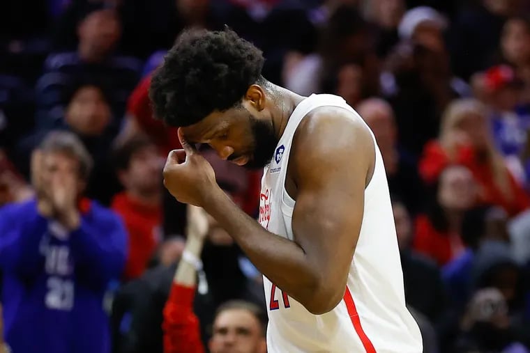 Sixers Joel Embiid wipes his head after fouling out in the second overtime.