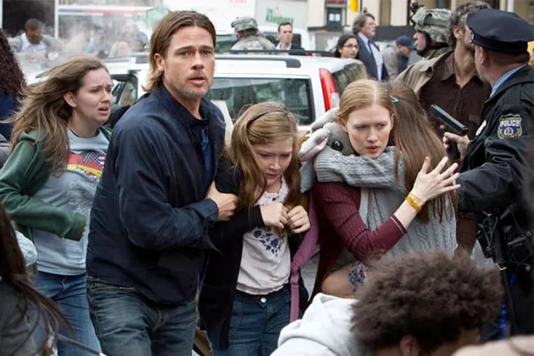 This publicity image released by Paramount Pictures shows, from center left, Brad Pitt as Gerry Lane, Abigail Hargrove as Rachel Lane, and Mireille Enos as Karin Lanein a scene from "World War Z." (AP Photo/Paramount Pictures, Jaap Buitendijk)
