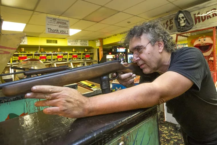 Randy Senna plays one of his favorite shooting-range games in his Wildwood arcade.