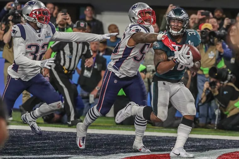 Eagles running back Cory Clement catches a touchdown pass in the third quarter of the Super Bowl, while avoiding Patriots defender Marquis Flowers.