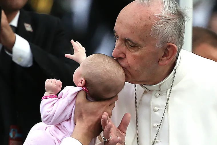 Pope Francis kisses a baby before he speaks at Independence Hall in Philadelphia, Pa. on Sept. 26, 2015.