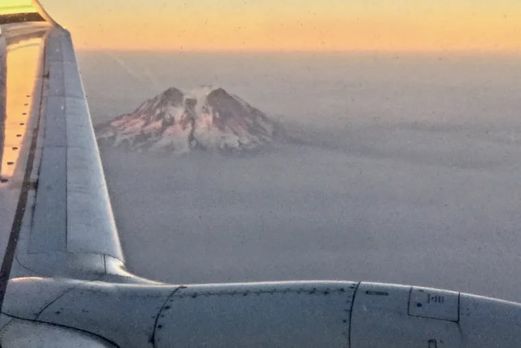 Smoke from Western forest fires this past summer shroud Mount Rainier in Washington State. Trip insurance can help if natural disasters impact your vacation plans.