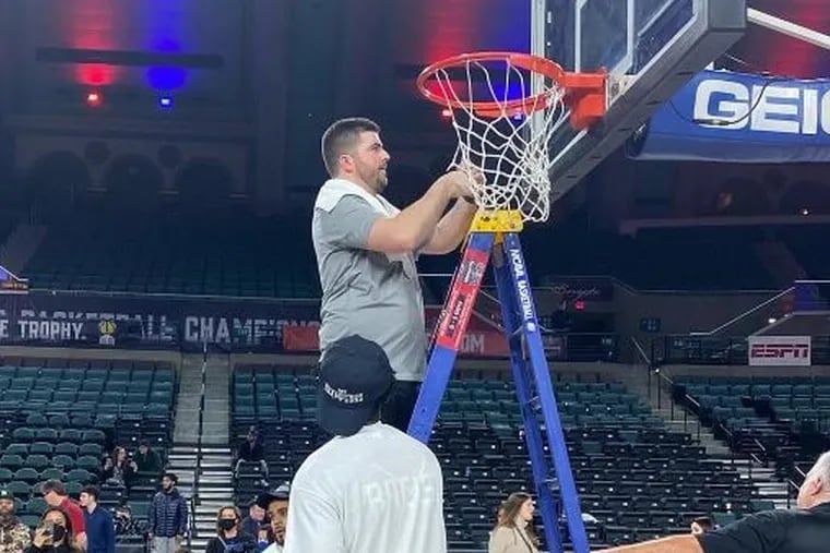 St. Peter's assistant Ryan Whalen cuts down the net after the Peacocks won the MAAC title.
