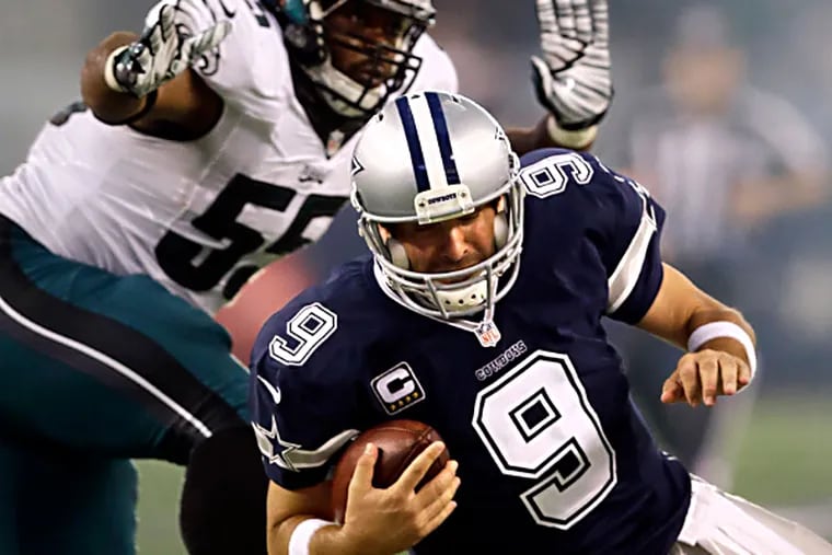 Tony Romo is sacked by Brandon Graham during the first half.  (AP Photo/Tim Sharp)