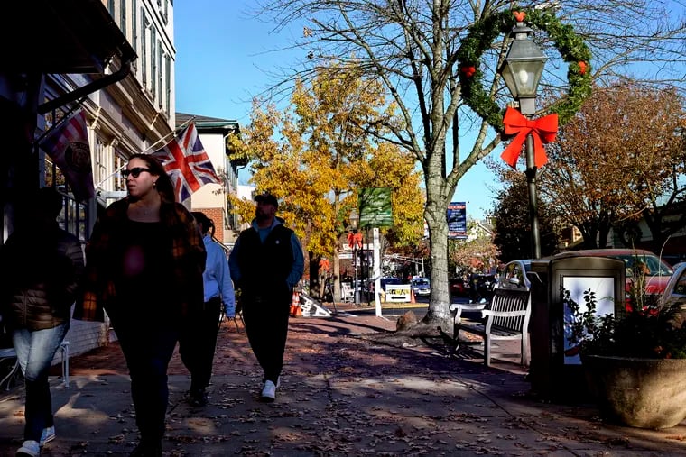 Shoppers pass the English Gardener Gift Shop (left) on Kings Highway in downtown Haddonfield as small businesses are preparing for the holiday season.