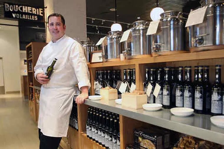 Adam DeLosso, chef de cuisine and general manager at Garces Trading, with olive oil canisters ready for customers to fill their own bottles at the market-cafe-wine boutique, a novel Pennsylvania hybrid.