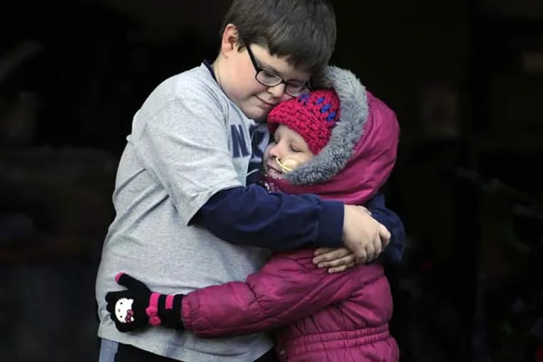 Emma Duffin, 8, gets a hug from her brother Alex, 11, at home in Enfield, Conn., on November 20, 2014. Emma was diagnosed with a rare form of leukemia last year and has had to undergo a bone marrow transplant and months of radiation and chemotherapy. Alex was the bone-marrow donor. (Stephen Dunn/Hartford Courant/TNS)