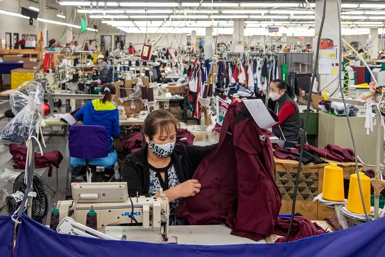 Workers sew garments at the Boathouse Sports plant floor on Hunting Park Avenue in Philadelphia. Boathouse is trying to reinvent itself with new products.