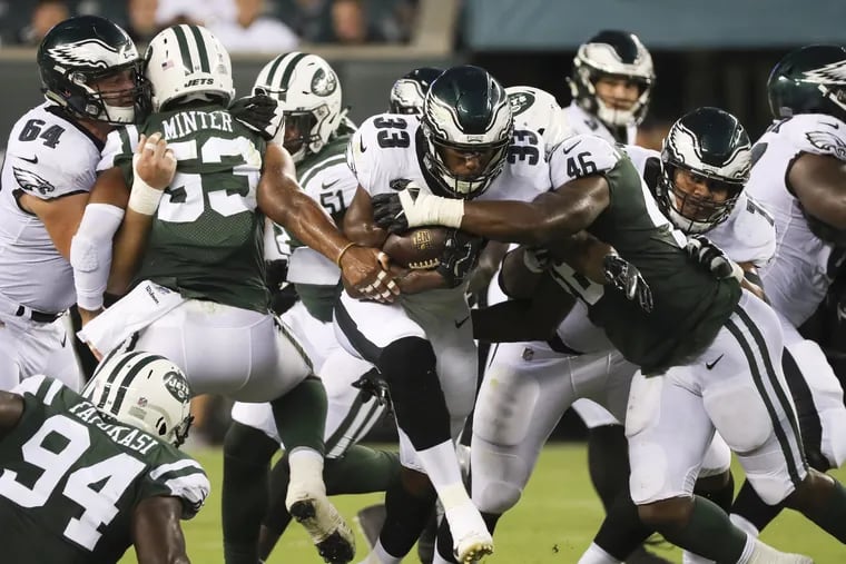 Eagles running back Josh Adams runs with football against New York Jets linebacker Neville Hewitt in the first-quarter during a preseason game on Thursday, August 30, 2018. MICHAEL BRYANT / Staff Photographer