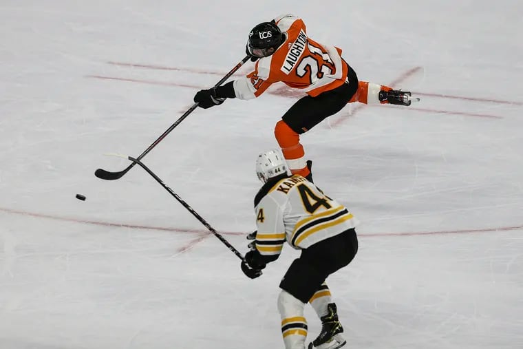 Flyers forward Scott Laughton taking a shot as the Bruins' Steve Kampfer defends during an April 6 game at the Wells Fargo Center.