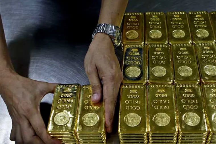 Gold futures dropped $140 to $1,361 an ounce. Gold has lost $203 an ounce in 2 days. (Associated Press)