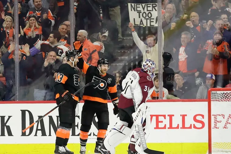 The sign being held in the background seems appropriate for Claude Giroux (center), who is striving for a strong finish as the Flyers make their playoff push.