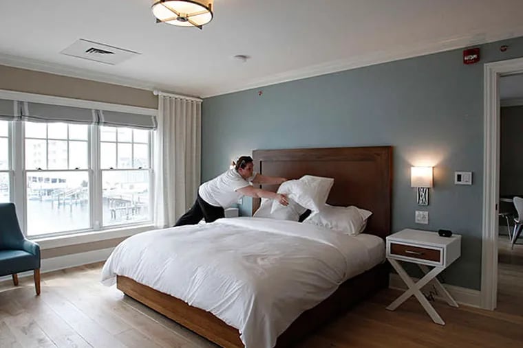 Chelsea Hengstler makes up the bed in a bay-view suite at The Reeds at Shelter Haven. Business people in Stone Harbor say the additional visitors drawn by the new hotel might make the town more of a destination resort. (Michael S. Wirtz/Staff)