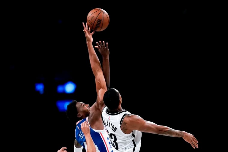 Sixers forward Paul Reed (left) and Brooklyn Nets forward Nic Claxton battle for the ball at tip-off during the preseason game Monday.