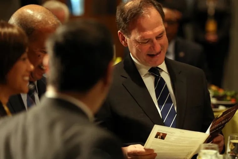 Supreme Court associate Justice Samuel A. Alito Jr. looks over the program before accept a citizenship award during a luncheon at Community College of Philadelphia on Jan. 15, 2015.  ( DAVID MAIALETTI / Staff Photographer )